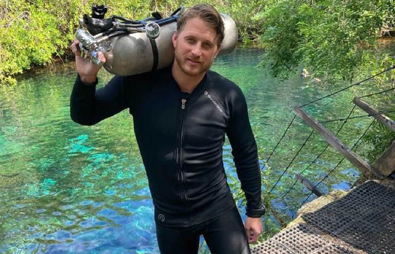 Diver holding a Scuba Tank wearing Sharkskin Titanium Top